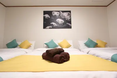 a room with three beds with a towel on the bed at HOTEL LUANA in NISHIKI in Tokyo