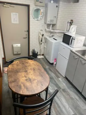 a kitchen with a wooden table and a kitchen with appliances at 1\u968e 2025\u5e743\u6708\u30aa\u30fc\u30d7\u30f3 \u5c0f\u5ca9\u5f92\u6b6915\u5206 \u53ce\u5bb94\u4eba \u6210\u7530\u7fbd\u7530\u304b\u3089\u30d0\u30b9\u76f4\u901a in Tokyo