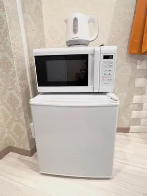 a microwave sitting on top of a white refrigerator at Ikebukuro-Kanamecho Studio Comfortable&Central 2F in Tokyo