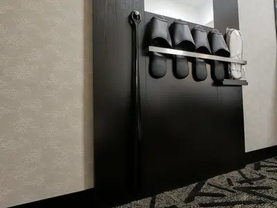 a black refrigerator with a rack of shoes at APA Hotel Suidobashi Ekimae in Tokyo