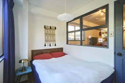a bedroom with a white bed and a window at HOTEL HONjoy in Tokyo