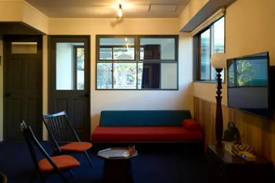 a living room with a couch and a table and windows at HOTEL HONjoy in Tokyo