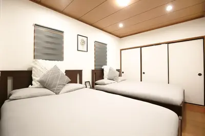 two beds in a room with white walls at \u9280\u5ea7\u7dda\u3059\u3050\u8fd1\u304f \u6b74\u53f2\u5bfa\u9662\u5de1\u308a\u306b\u6700\u9069 \u677e\u304c\u8c37\u306e\u9759\u304b\u306a\u4e00\u8ed2\u5bb6 Sio1g in Tokyo