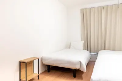 a hotel room with two beds and a table at \u6839\u5cb8\u6238\u5efa\u3066 in Tokyo