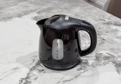 a black coffee pot sitting on a counter at \u6839\u5cb8\u6238\u5efa\u3066 in Tokyo