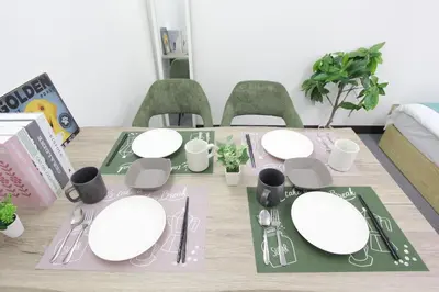 a dining room table with white plates and silverware at LUANA in SHIN-KOUENJI in Tokyo