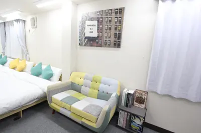 a bedroom with a bed and a chair and a book shelf at LUANA in SHIN-KOUENJI in Tokyo