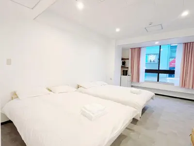 two beds in a white room with a window at hananosato \u9ad8\u7530\u99ac\u5834 in Tokyo