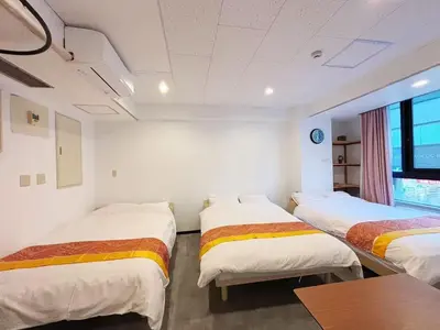 a room with three beds in it with a table at hananosato \u9ad8\u7530\u99ac\u5834 in Tokyo