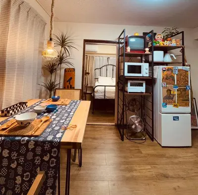 a living room with a table and a refrigerator at \u30cd\u30ae\u30cf\u30a6\u30b9,Negi House with Retro Vibes in Shopping Street,Group Friendly in Tokyo