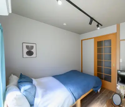 a bedroom with a bed with blue and white sheets at Sumida Skytree hostel in Tokyo