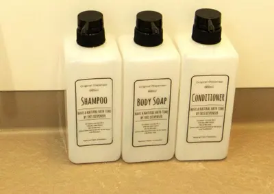 three bottles of shampoo and conditioner on a counter at Sumida Skytree hostel in Tokyo