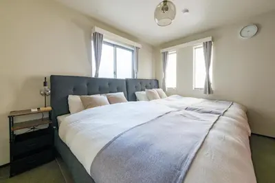 a bedroom with a large bed with white sheets at Make Your Hotel\u5e61\u30f6\u8c37 in Tokyo