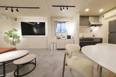a kitchen and living room with a white table and chairs at Make Your Hotel\u5e61\u30f6\u8c37 in Tokyo