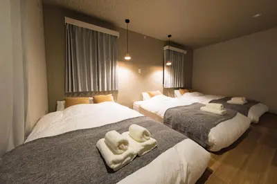 a bedroom with three beds with towels on them at Make Your Hotel\u5e61\u30f6\u8c37 in Tokyo