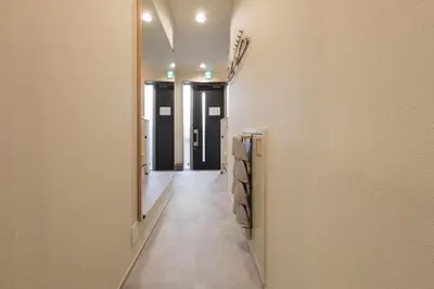 a hallway with a long corridor with black doors at Make Your Hotel\u5e61\u30f6\u8c37 in Tokyo