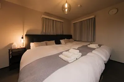 a bedroom with a large white bed with towels on it at Make Your Hotel\u5e61\u30f6\u8c37 in Tokyo