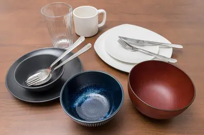a wooden table with plates and bowls and utensils at Ikebukuro Urban Retreat in Tokyo