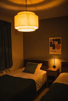 a bedroom with two beds and a light fixture at Ikebukuro Urban Retreat in Tokyo