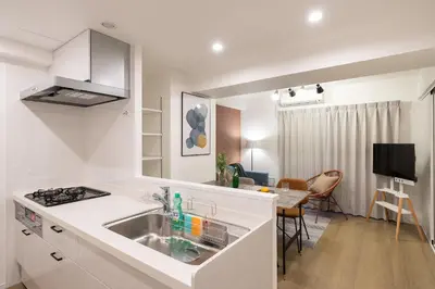 a white kitchen with a sink and a table at Teto\u65e9\u7a32\u7530 in Tokyo
