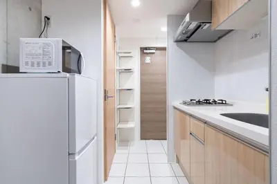 a kitchen with a white refrigerator and a sink at Exam\u9ad8\u7530\u99ac\u5834 in Tokyo