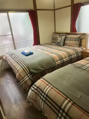 two beds sitting next to each other in a room at \u677f\u6a4b - \u4e09\u56fd\u5c45Guest House in Tokyo