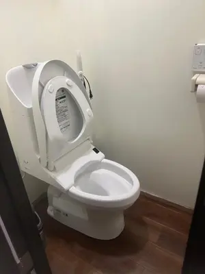 a white toilet with the seat up in a bathroom at \u677f\u6a4b - \u4e09\u56fd\u5c45Guest House in Tokyo