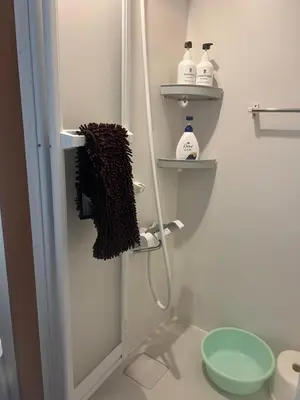 a bathroom with a shower with shelves and a toilet at \u677f\u6a4b - \u4e09\u56fd\u5c45Guest House in Tokyo