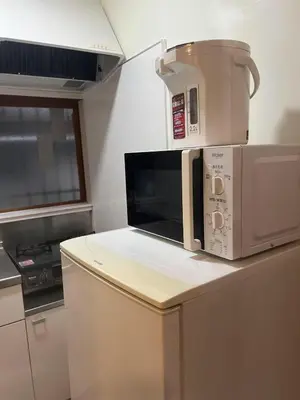 a microwave sitting on top of a kitchen counter at \u677f\u6a4b - \u4e09\u56fd\u5c45Guest House in Tokyo