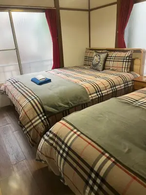 two beds sitting next to each other in a room at \u677f\u6a4b - \u4e09\u56fd\u5c45Guest House in Tokyo