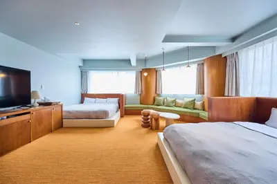 a hotel room with two beds and a flat screen tv at Hotel Vintage Tokyo Meguro Fudomae in Tokyo