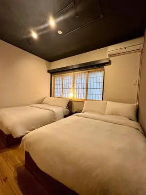 two beds in a room with two windows at The Hills Suite Daikanyama & Omotesando-Shibuya-Harajuku-Meiji Shrine & 10-minute walk from Daikanyama in Tokyo