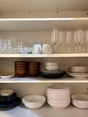 a shelf filled with dishes and wine glasses at The Hills Suite Daikanyama & Omotesando-Shibuya-Harajuku-Meiji Shrine & 10-minute walk from Daikanyama in Tokyo