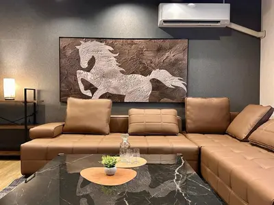 a living room with a brown couch and a table at The Hills Suite Daikanyama & Omotesando-Shibuya-Harajuku-Meiji Shrine & 10-minute walk from Daikanyama in Tokyo