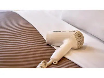 a tan hairdryer sitting on top of a bed at The OneFive Tokyo Kameido - Vacation STAY 64577v in Tokyo