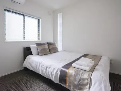a bedroom with a large bed with white sheets and pillows at Four Seasons Yado1 in Tokyo