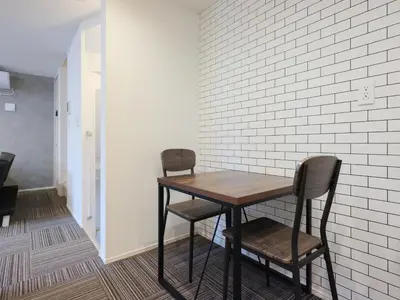 a table and two chairs sitting next to a wall at Four Seasons Yado1 in Tokyo