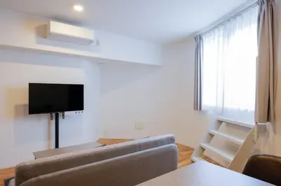 a living room with a couch and a flat screen tv at \u30b3\u30eb\u30c6\u30a3\u30fc\u30ec\u56db\u8c37\u672c\u5869\u753a in Tokyo