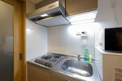 a small kitchen with a sink and a microwave at \u30b3\u30eb\u30c6\u30a3\u30fc\u30ec\u56db\u8c37\u672c\u5869\u753a in Tokyo