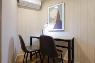 a room with two chairs and a desk with a lamp at \u30b3\u30eb\u30c6\u30a3\u30fc\u30ec\u56db\u8c37\u672c\u5869\u753a in Tokyo