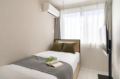 a small bedroom with a bed with a book on it at Brio\u9ad8\u4e95\u6238 in Tokyo