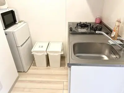 a small kitchen with a sink and a refrigerator at Comma House Nishi-Ikebukuro 3F in Tokyo