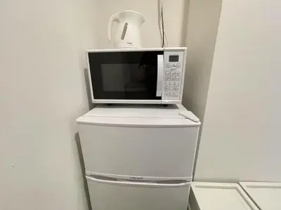 a microwave oven sitting on top of a refrigerator at Comma House Nishi-Ikebukuro 3F in Tokyo