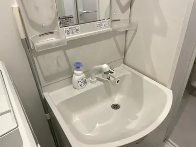 a bathroom sink with a bottle of soap on it at Comma House Nishi-Ikebukuro 3F in Tokyo
