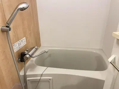 a white bath tub in a bathroom with a telephone at Comma House Nishi-Ikebukuro 3F in Tokyo