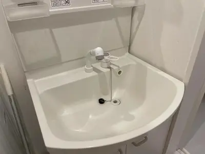a white sink in a bathroom with a mirror at Comma House Nishi-Ikebukuro 3F in Tokyo