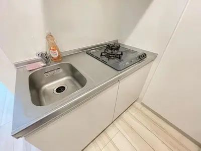 a kitchen with a sink and a stove at Comma House Nishi-Ikebukuro 3F in Tokyo