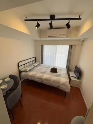 a bedroom with a bed and a table and a window at SHIBUYA Room in Tokyo