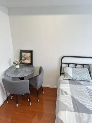 a bedroom with a table and chairs next to a bed at SHIBUYA Room in Tokyo