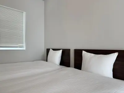 two twin beds in a room with a window at Lumiere Minami-Shinagawa B in Tokyo
